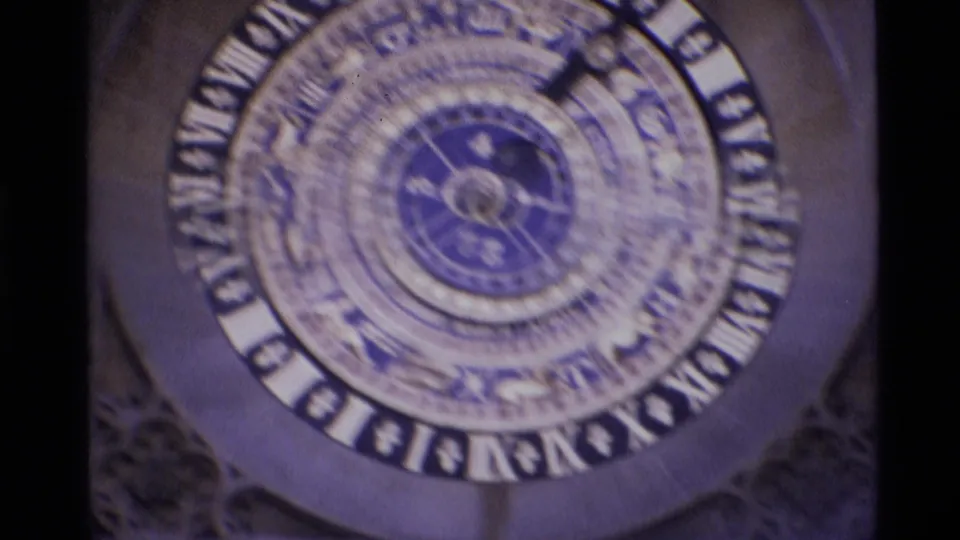 Close 1969 London view of an ornate round clock face with Roman numerals, blue center details, and surrounding architectural decoration.