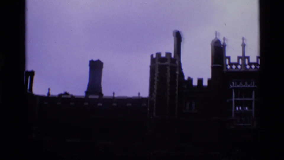 1969 London 8mm frame with a dark towered roofline, chimney stack, battlements, and a decorative window section.