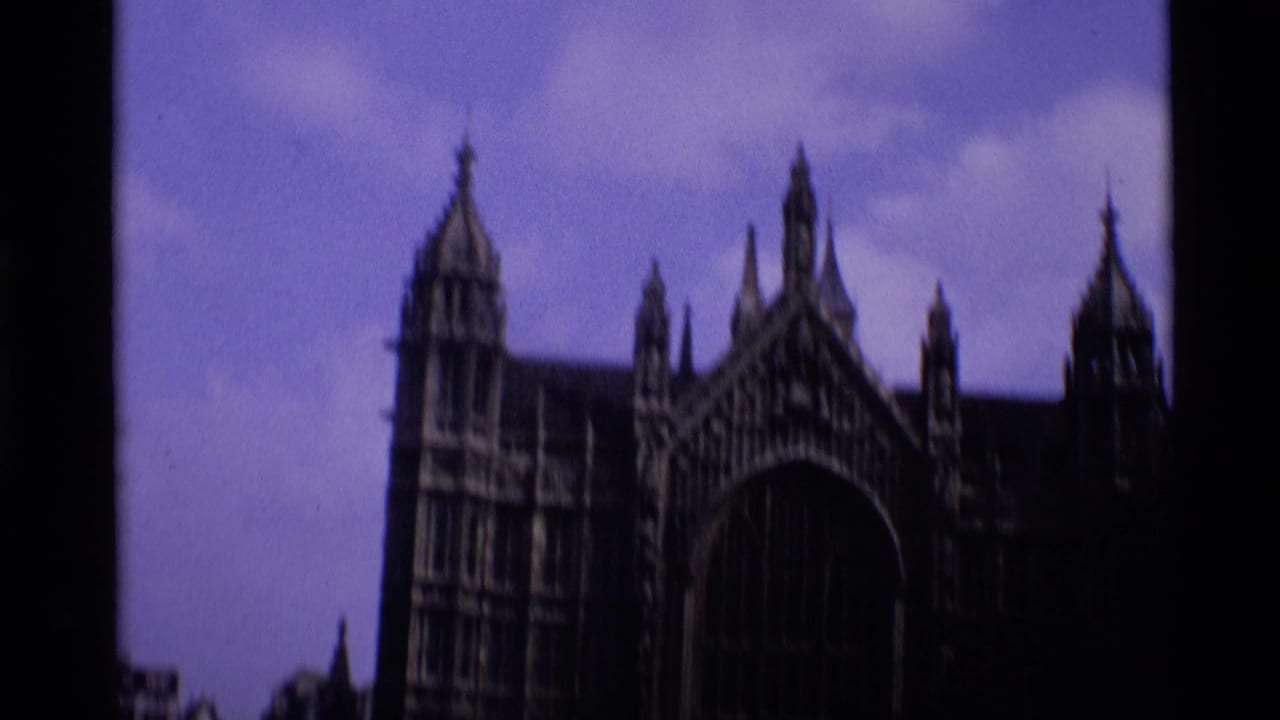 1969 London 8mm frame showing a dark Gothic landmark exterior with pointed spires and a large arched window against a purple sky.