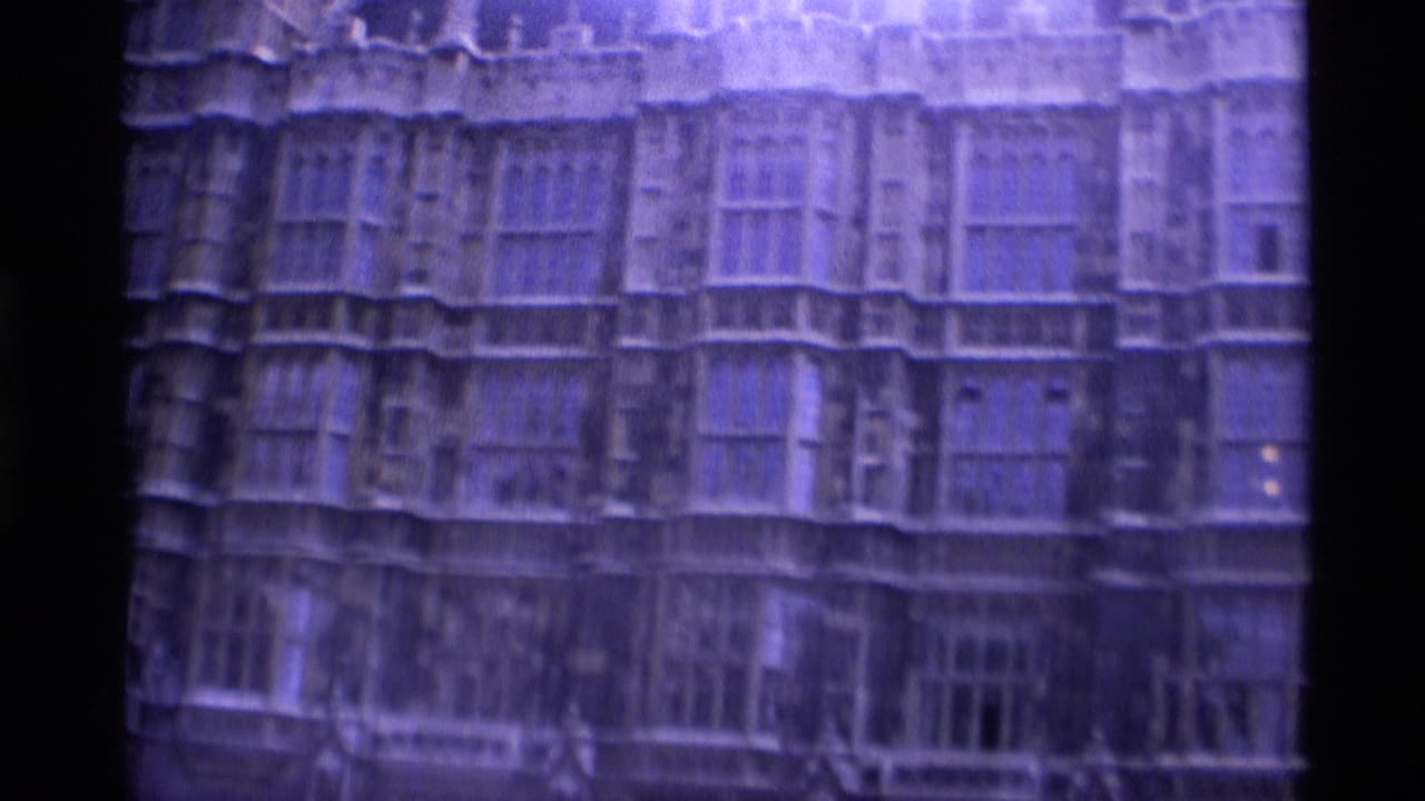 Soft 8mm view of a large Gothic stone facade with rows of tall windows.
