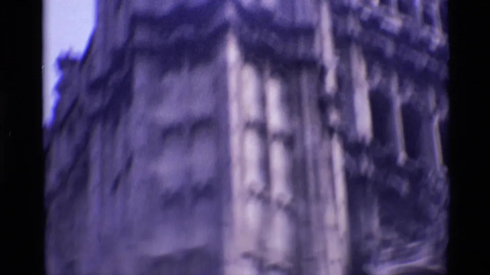 1969 London frame showing blurred close-up Gothic stonework, with vertical carvings and exterior church detail.
