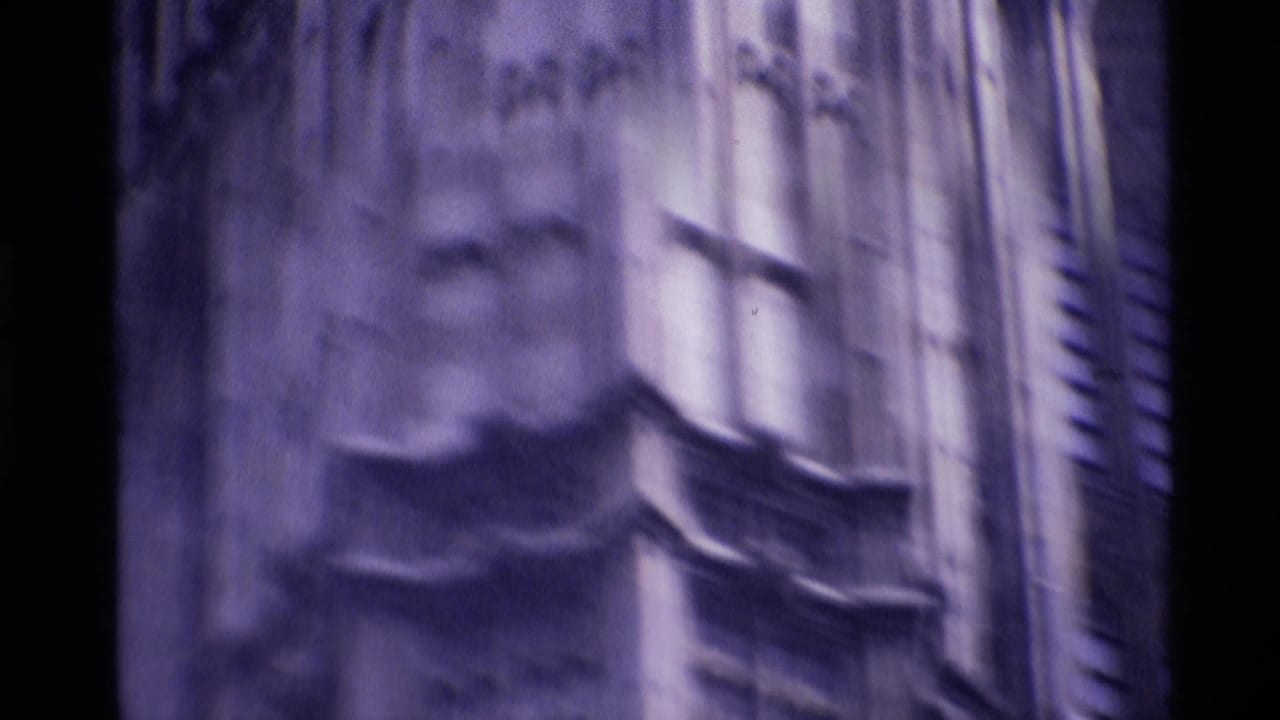 1969 London 8mm frame showing a blurred close view of Gothic stonework and vertical architectural detail.