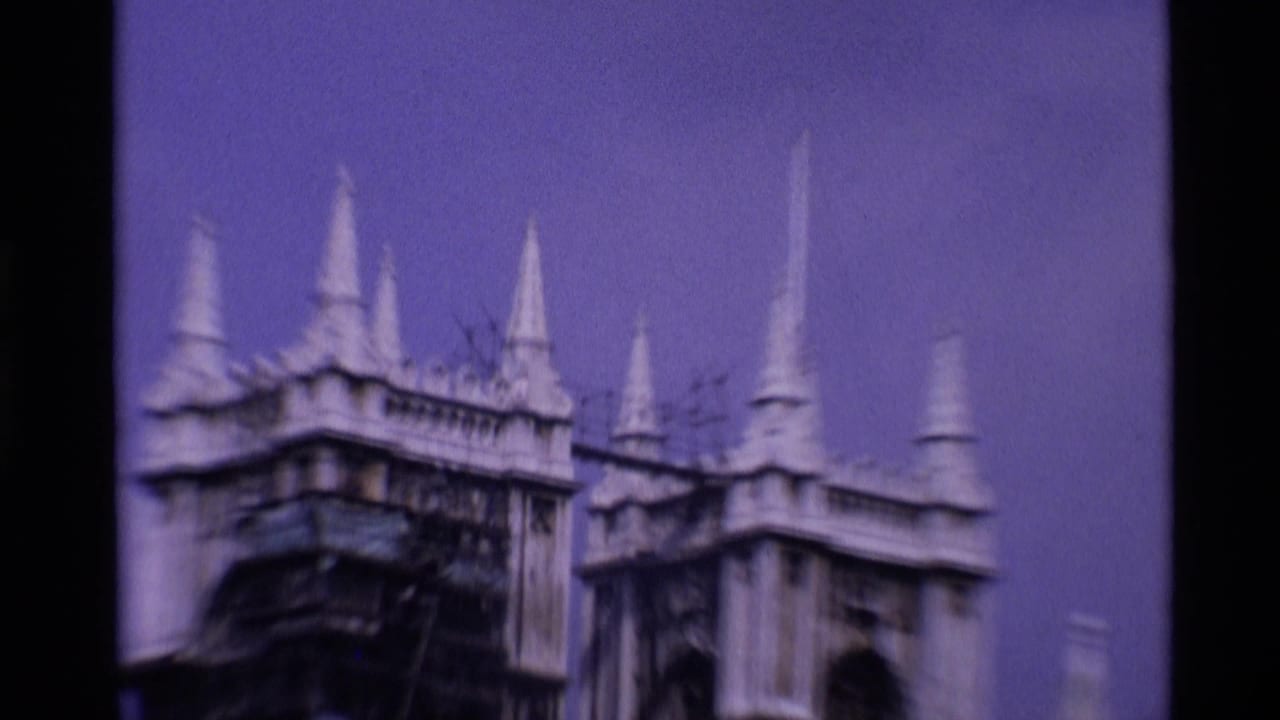 1969 London 8mm frame showing an ornate Gothic roofline with pointed spires and soft handheld blur.