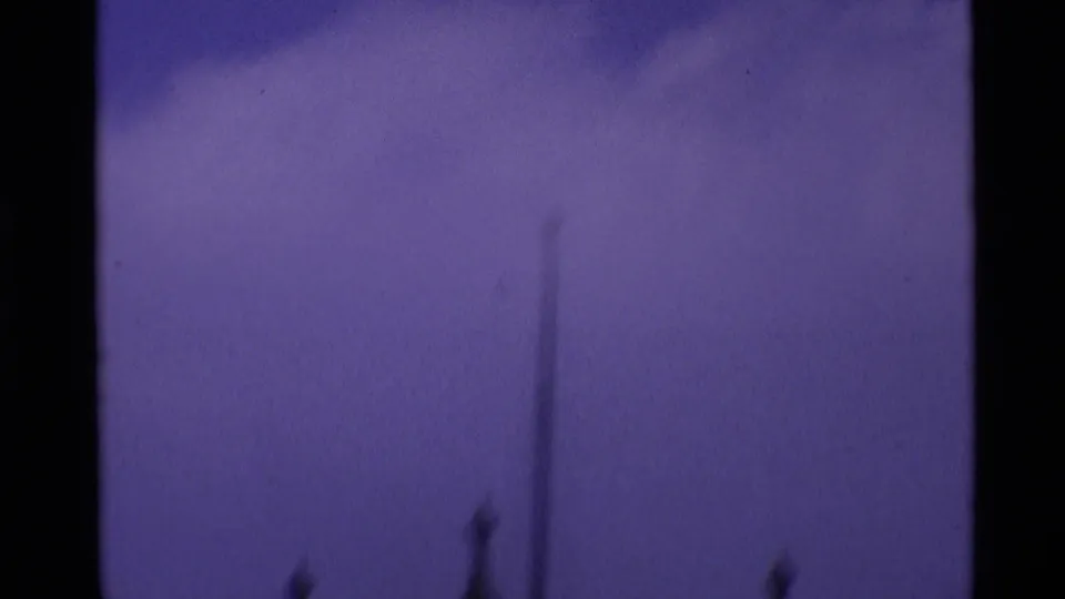 1969 London 8mm frame with a faint pointed spire rising above a dark, underexposed foreground band.