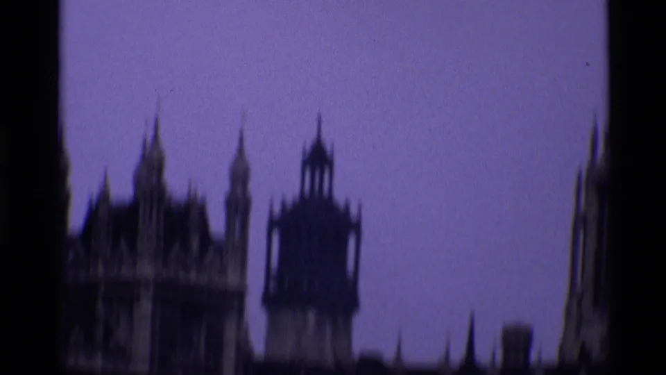 1969 London 8mm frame with a blurred Palace of Westminster roofline and central tower silhouette during handheld movement.