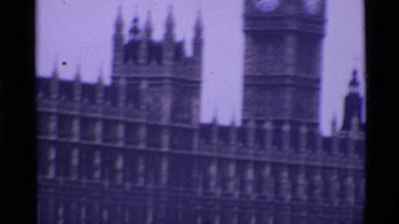 1969 London 8mm frame showing the Elizabeth Tower clock face and Palace of Westminster facade in soft focus.
