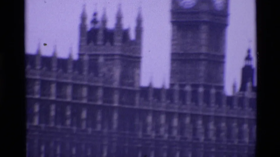 1969 London 8mm frame showing the Elizabeth Tower clock face and Palace of Westminster facade in soft focus.