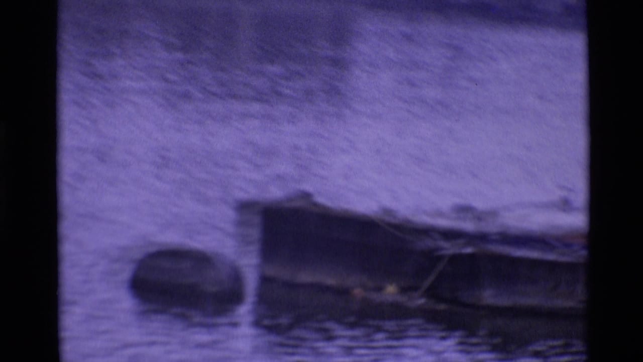 Small boats float on water in a soft, purple-shifted 1969 London home-movie frame.