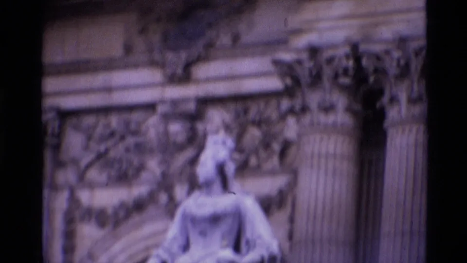 Soft 8mm frame of a pale stone statue and carved architectural detail, likely from a London landmark setting.