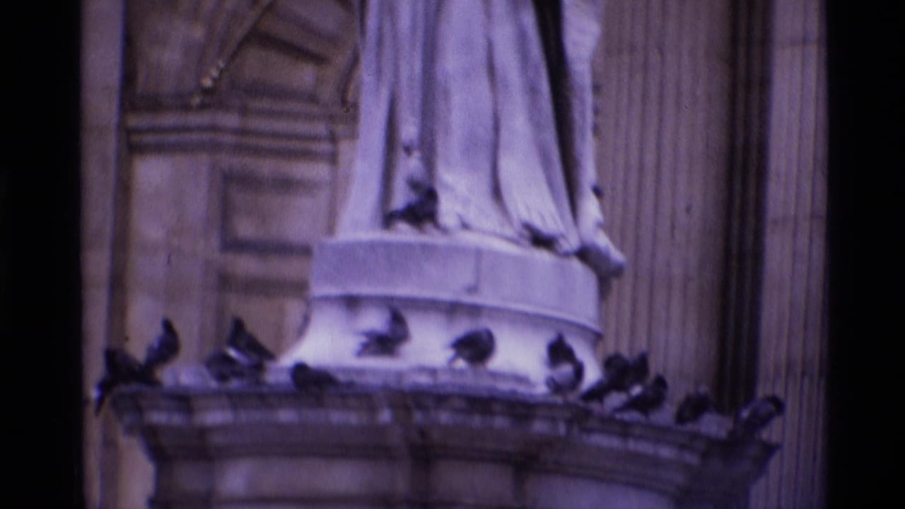 Pigeons perched around a stone statue pedestal on a grand building facade.