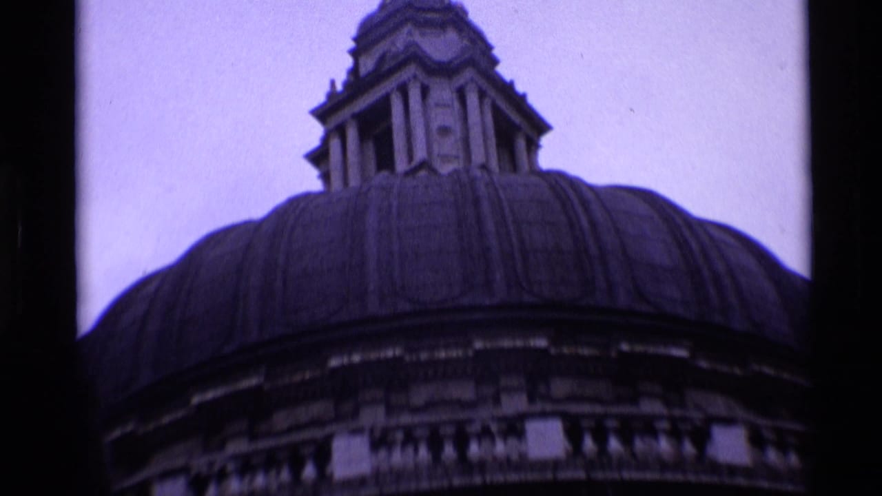 Low-angle view of St Paul's Cathedral dome and lantern against a pale sky.