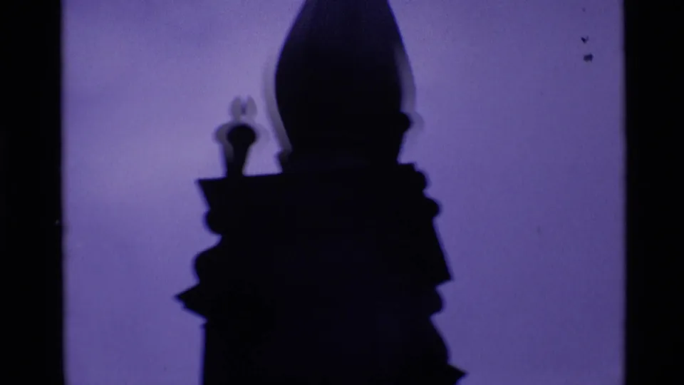 1969 London 8mm frame showing a silhouetted architectural spire or tower detail against a purple sky.