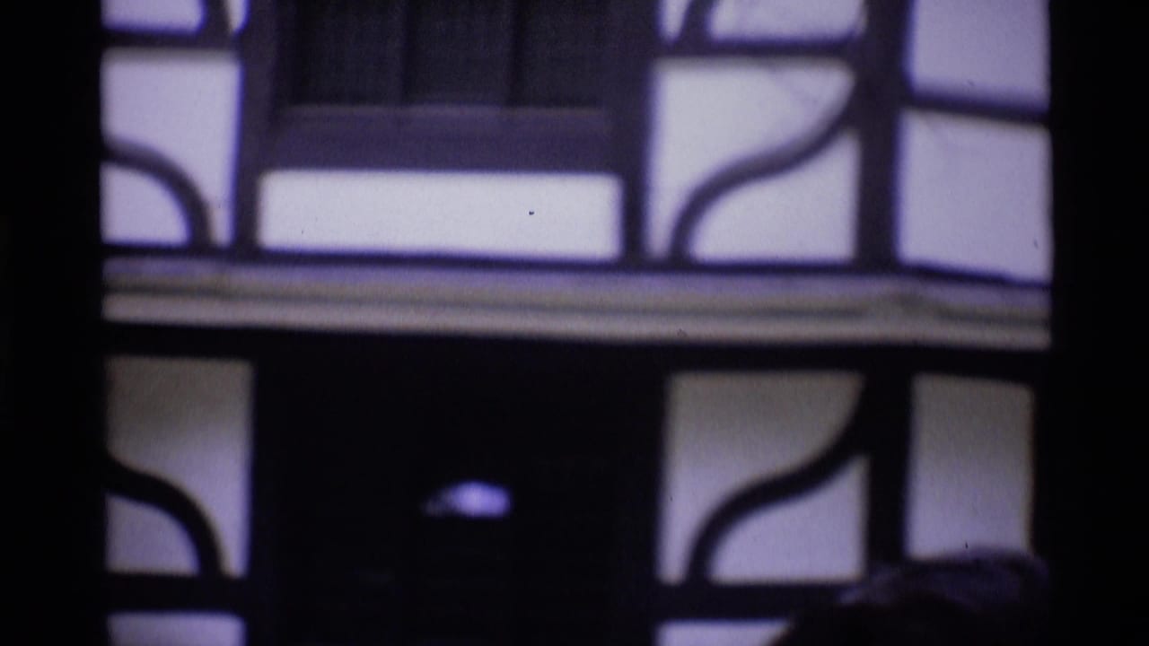Soft-focus 1969 London home-movie frame showing part of a half-timbered building facade in close view.