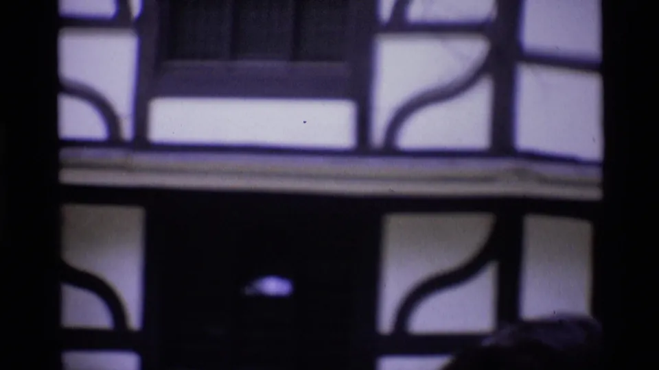 Soft-focus 1969 London home-movie frame showing part of a half-timbered building facade in close view.