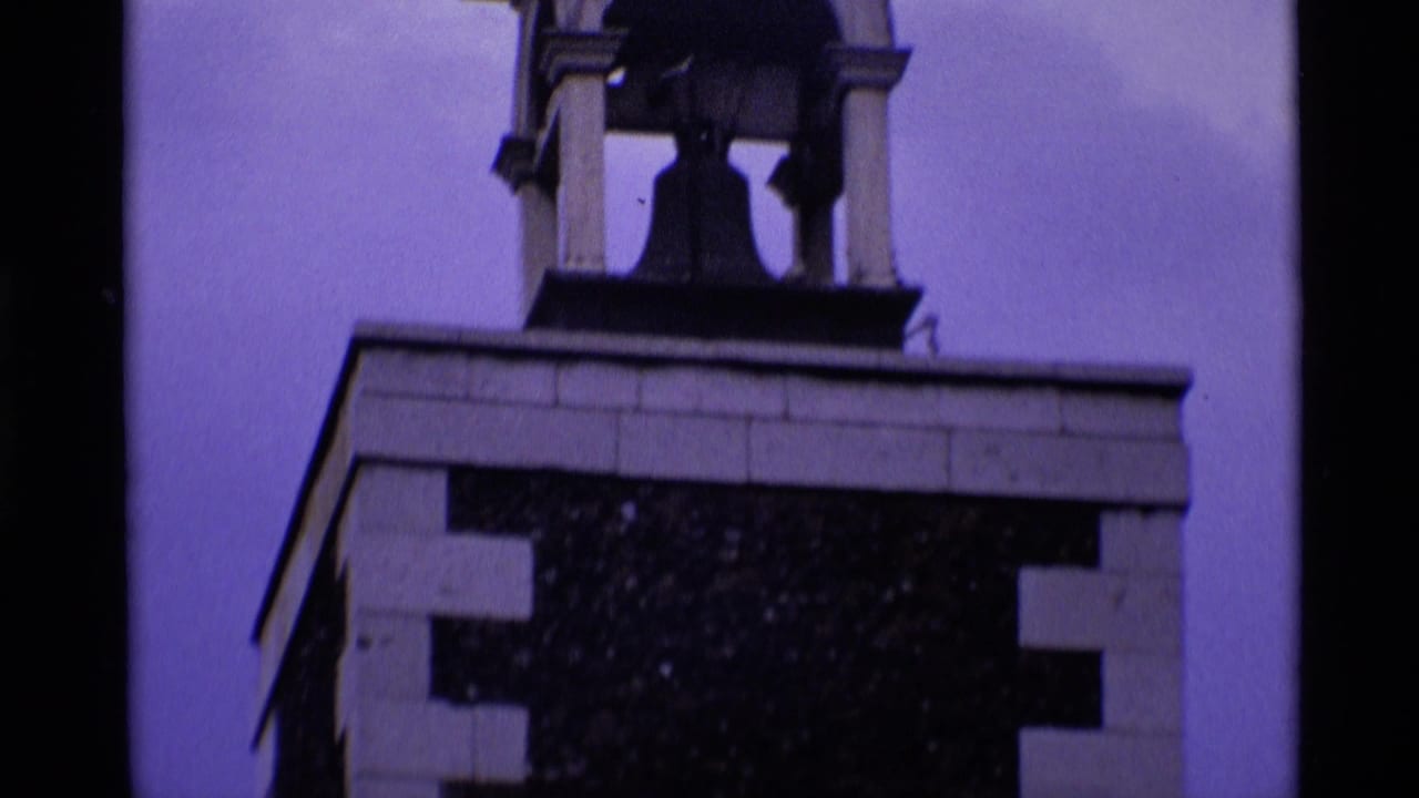 Bell chamber at the top of a brick clock tower.