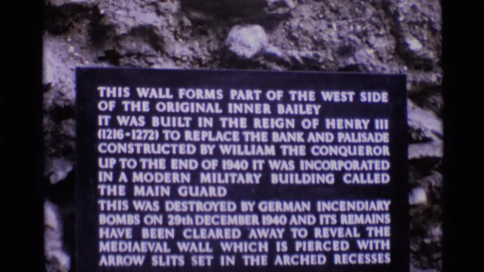 Visitor-shot 8mm view of a Tower of London plaque describing the Inner Bailey wall and wartime damage.