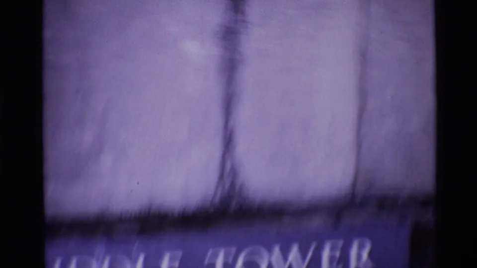Soft, motion-blurred 1969 London frame with a light-shirted passerby over partial Middle Tower signage.