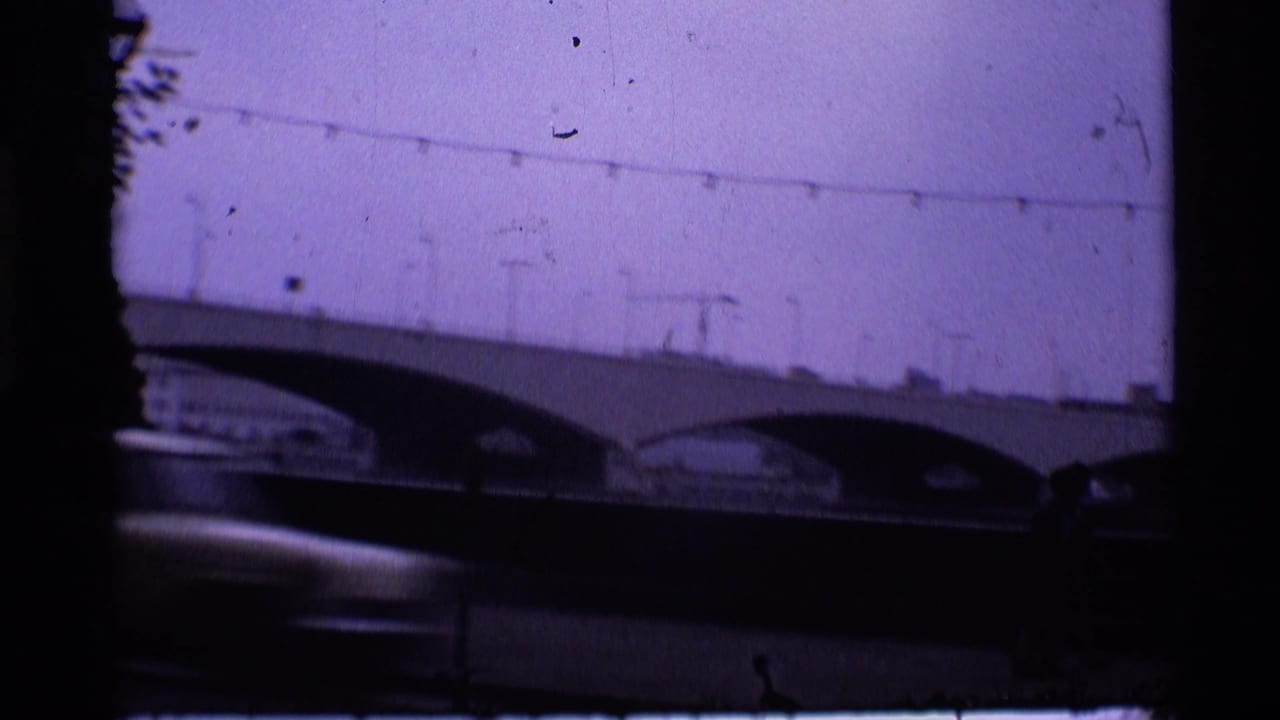 Arched bridge and streetlights with a motion-blurred car crossing the lower frame.