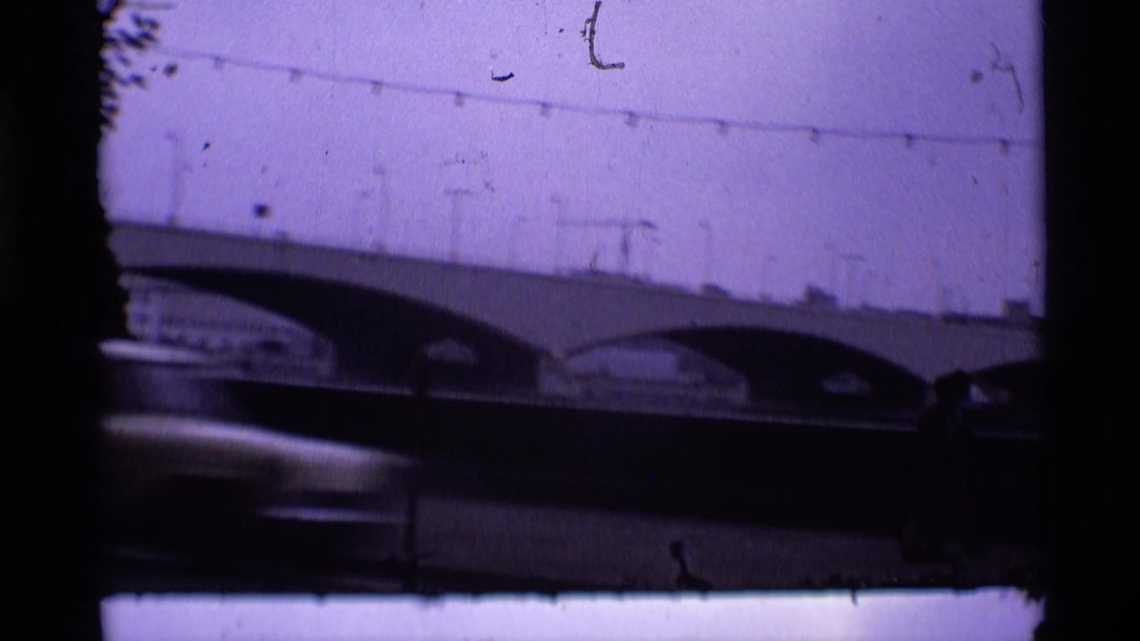 Low-angle view of an arched bridge seen through dark 8mm frame edges.