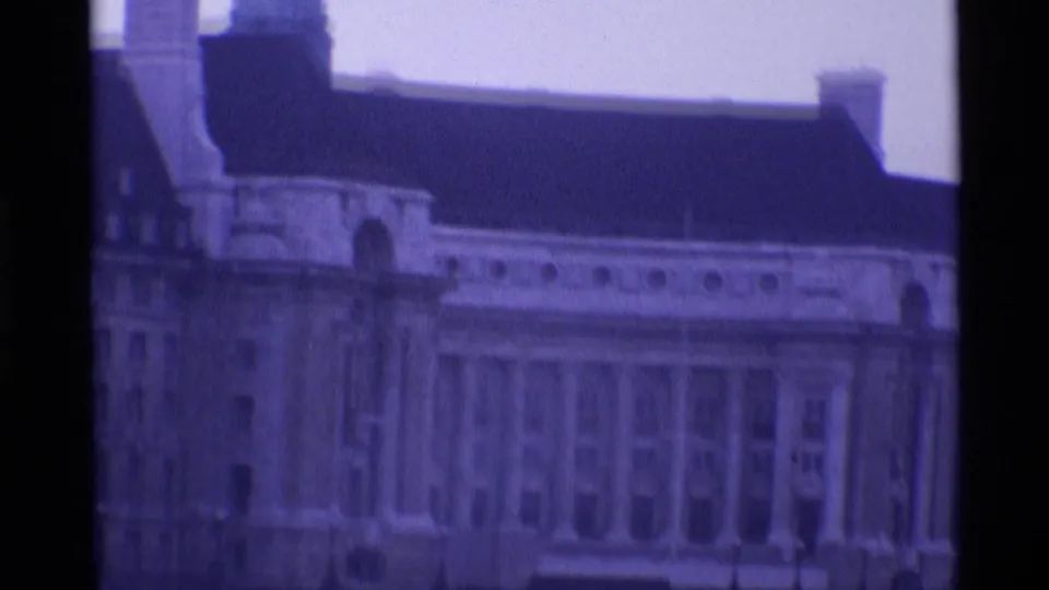 1969 London 8mm frame showing a closer section of the building with columns, arched details, roof edge and chimney base.