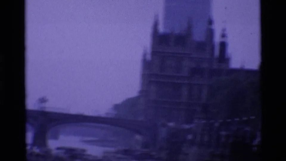 1969 London 8mm frame with the Houses of Parliament appearing beyond a Thames bridge in soft focus.