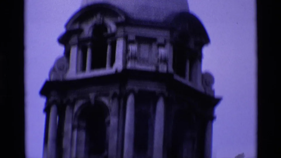 1969 London 8mm frame showing a soft, purple-tinted close view of an ornate domed stone tower and arched openings.
