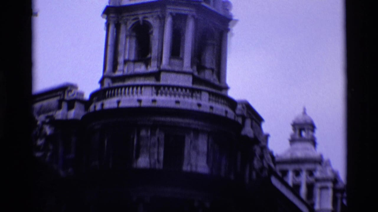 Ornate rounded building corner with tower details and another dome behind it.