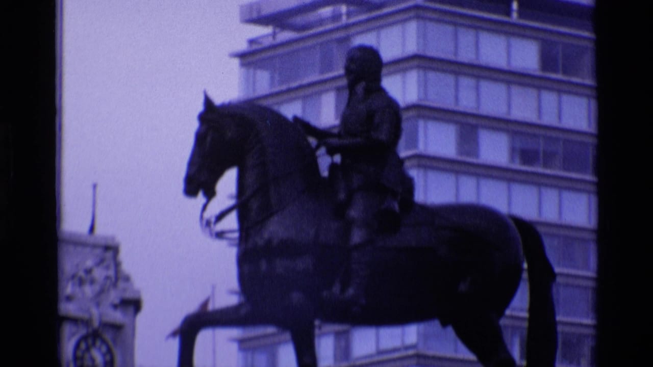 1969 London 8mm frame showing an equestrian statue in front of mid-century buildings with a strong purple-blue film cast.