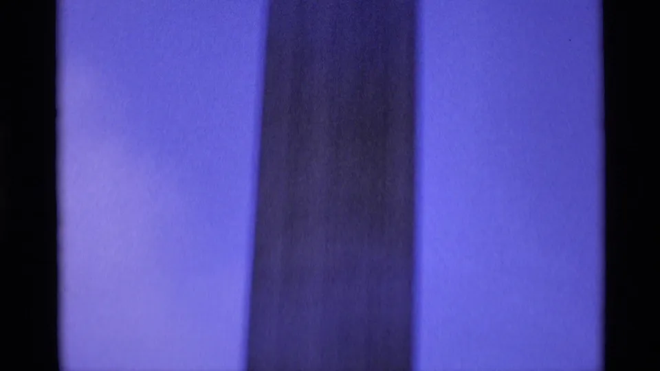 Blue-toned 1969 London home-movie frame showing a close vertical section of a monument column.