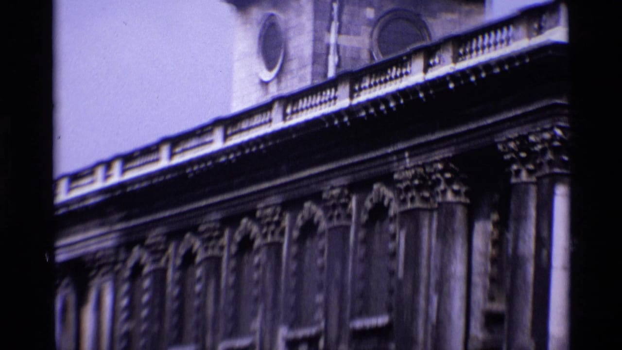 1969 London 8mm frame showing an ornate classical stone facade with columns, arched details, and dark film edges.