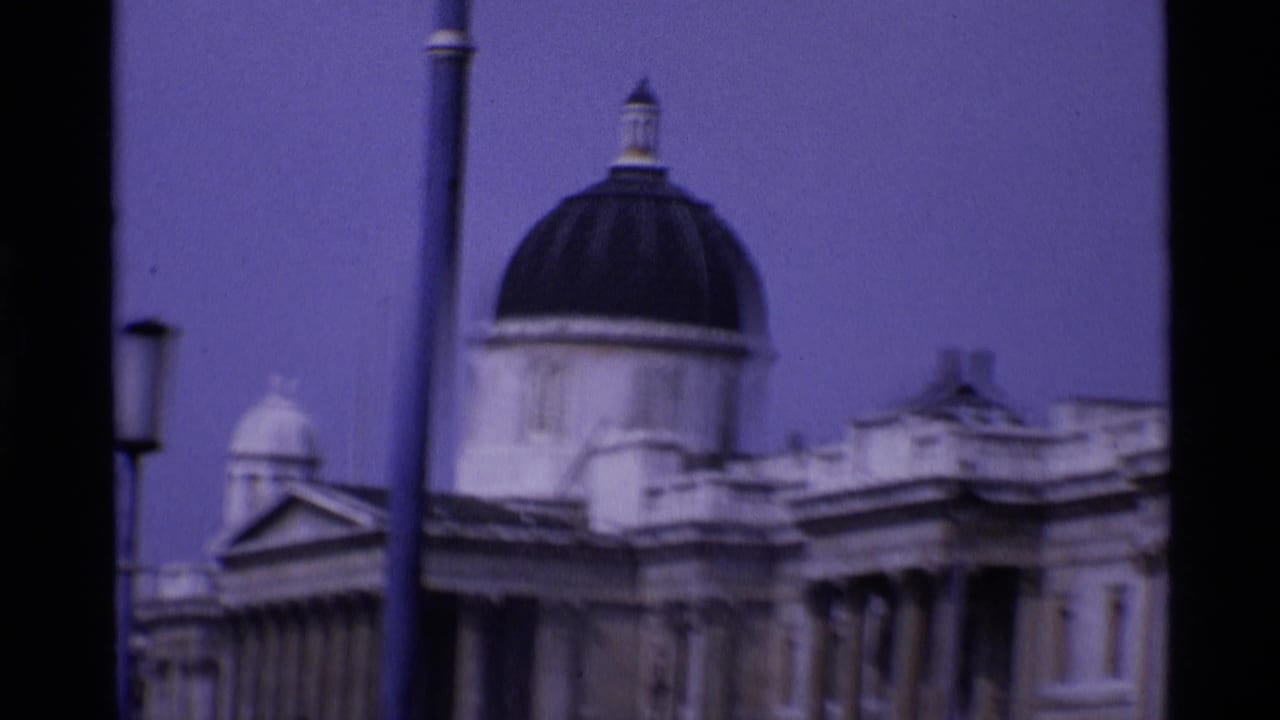 Soft 8mm view of a domed classical building and street lamps behind dark film borders.