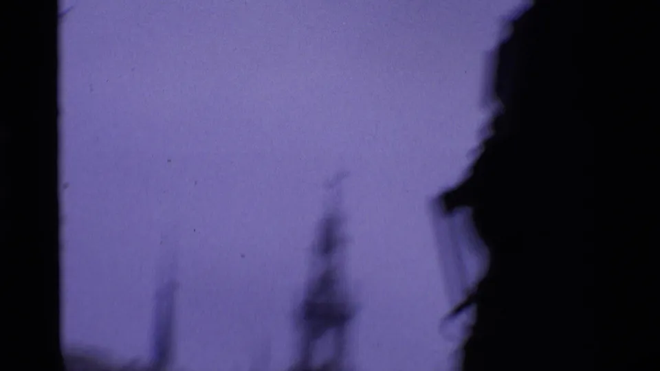 Soft 8mm London street frame with purple sky, dark border shapes, and a blurred steeple-like architectural silhouette.
