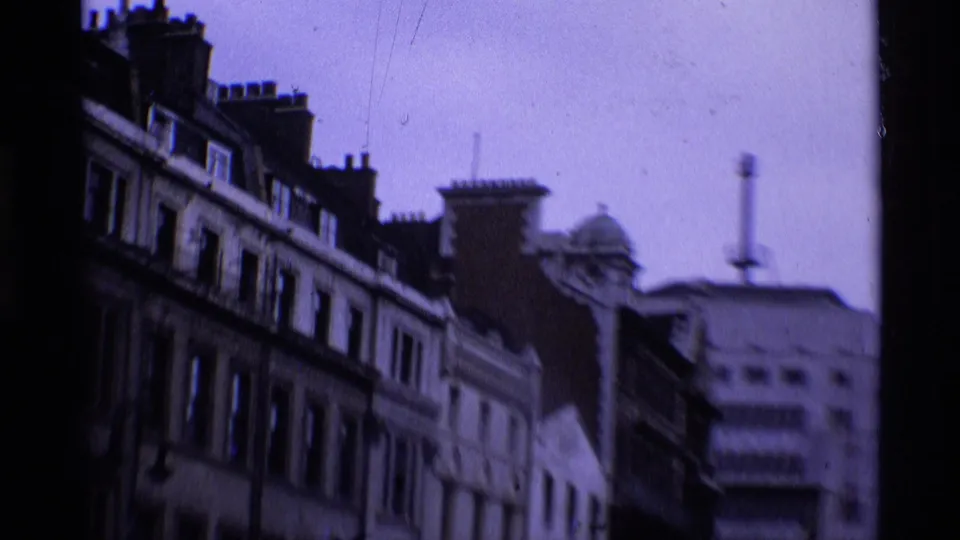 1969 London street-facing roofline with older facades, chimney stacks, rows of windows, and distant urban buildings.