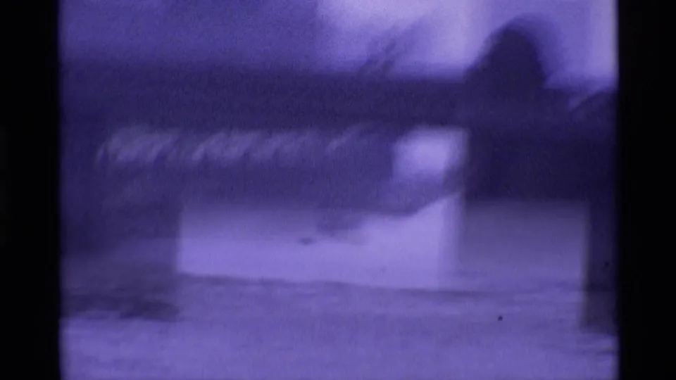 1969 London 8mm frame showing a hazy River Thames view beneath or near a bridge, with soft focus and dark film edges.