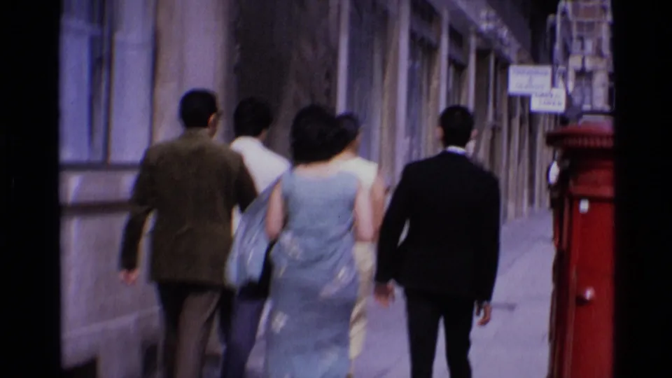 1969 London street view with adults walking away from the camera near a red British postbox on Aldwych.