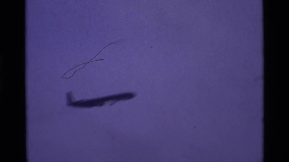 Distant airliner appears to climb after takeoff in a grainy 1969 London airport home-movie frame.