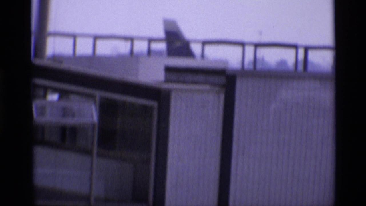 1969 8mm view from London airport glass toward terminal structures and part of a Canadian-marked aircraft.
