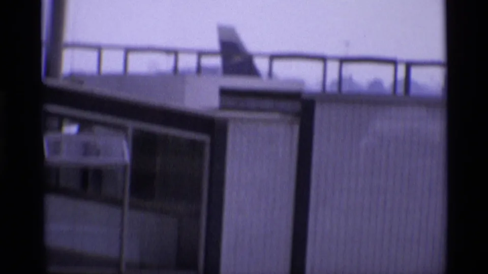 1969 8mm view from London airport glass toward terminal structures and part of a Canadian-marked aircraft.
