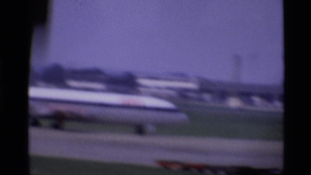 A passenger jet appears beyond the aircraft window frame during takeoff at a London airport in 1969.