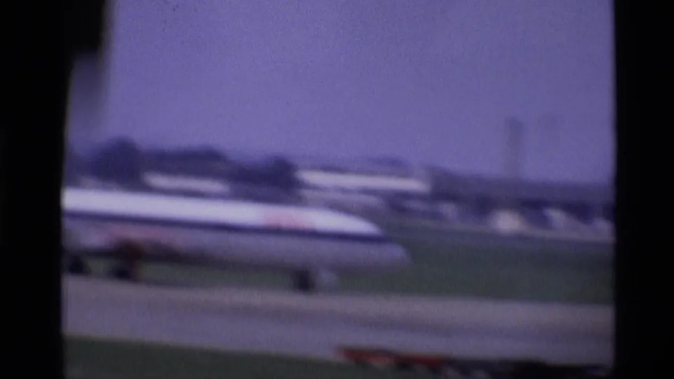 A passenger jet appears beyond the aircraft window frame during takeoff at a London airport in 1969.