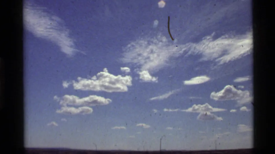 1972 Holland Lake, Montana frame with scattered cumulus and wispy cirrus clouds above a nearly flat horizon.