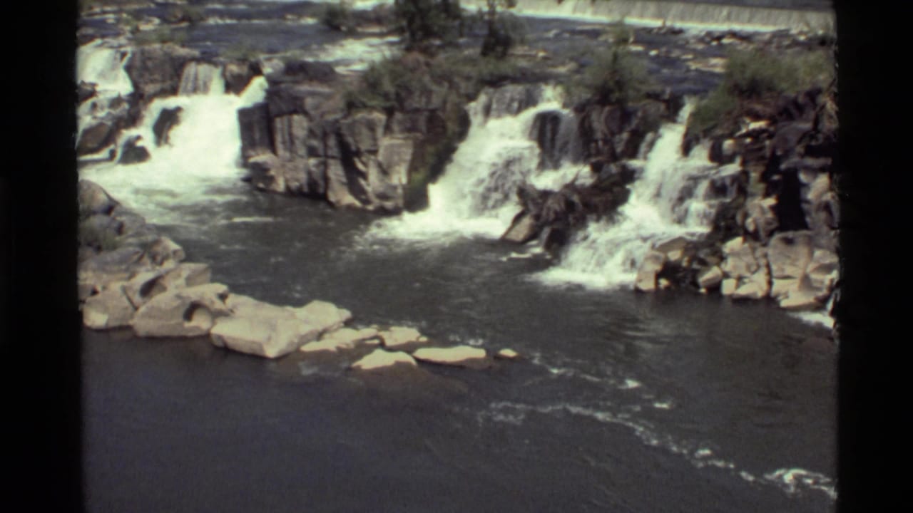 Rock ledges with several small waterfalls spilling into a dark pool below.