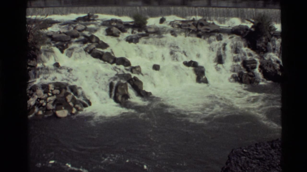 1972 Holland Lake, Montana 8mm frame showing a waterfall dropping over dark jagged rocks into turbulent water.