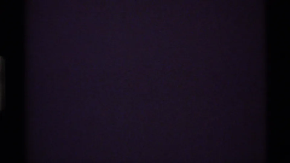 Final 8mm frame fades toward black with only faint purple film density and edge darkness visible.