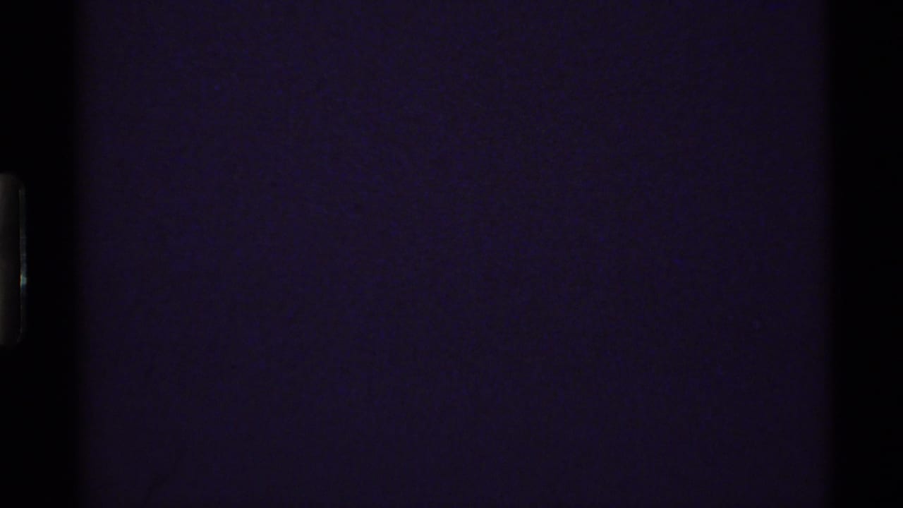 Opening 8mm frame from the 1972 Holland Lake clip, largely dark with only faint grain and edge exposure visible.