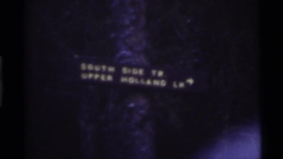 An in-camera title card appears over dark forest footage, identifying Holland Lake, Montana, and 1972.