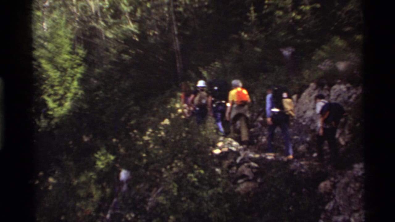 1972 Holland Lake, Montana footage appears to show hikers moving through dense forest on a rocky trail.