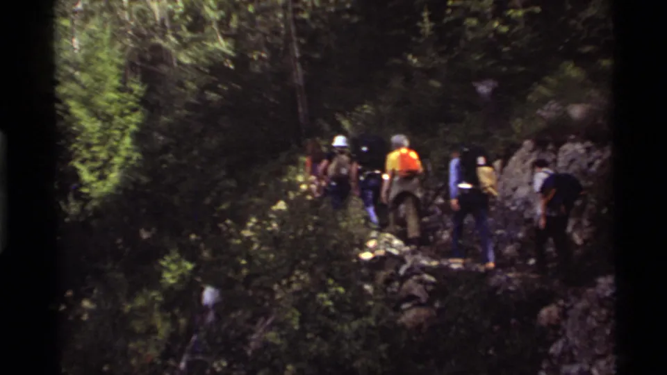1972 Holland Lake, Montana footage appears to show hikers moving through dense forest on a rocky trail.