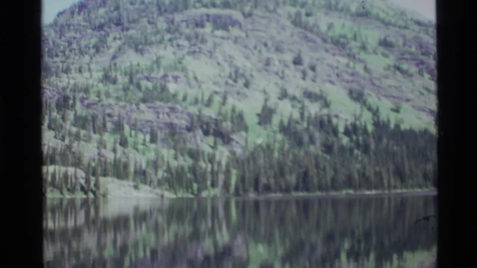 Holland Lake mountain scenery with evergreen shoreline and muted 8mm color from the 1972 home movie.