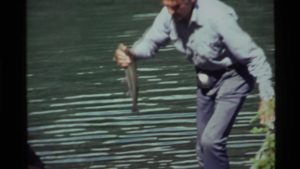 At Holland Lake, Montana in 1972, the man holds the fish up for the camera in a close, softly focused 8mm frame.